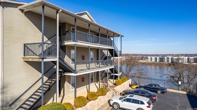 view of building exterior with stairway and a water view