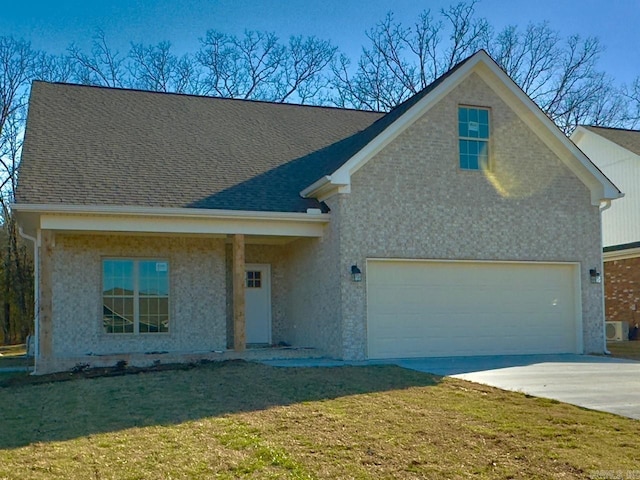 view of front of home with an attached garage, concrete driveway, a front lawn, and roof with shingles