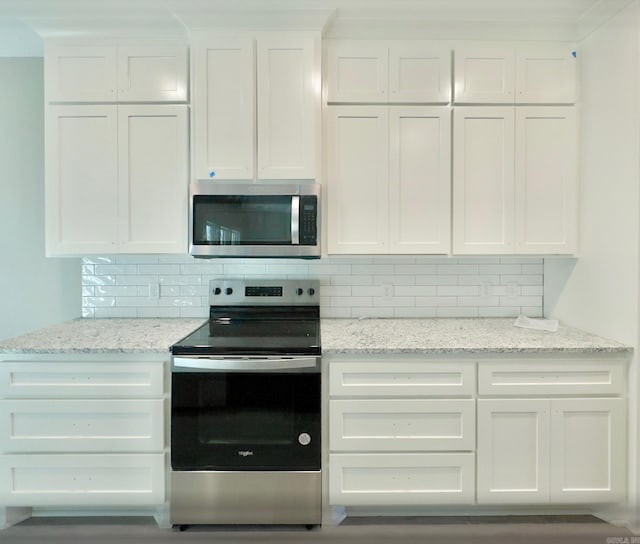 kitchen featuring light stone counters, tasteful backsplash, appliances with stainless steel finishes, and white cabinetry