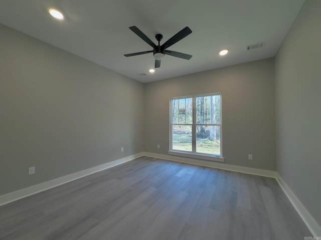 spare room featuring recessed lighting, visible vents, baseboards, and dark wood-style flooring