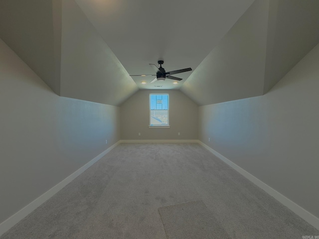 additional living space featuring baseboards, carpet, lofted ceiling, and a ceiling fan