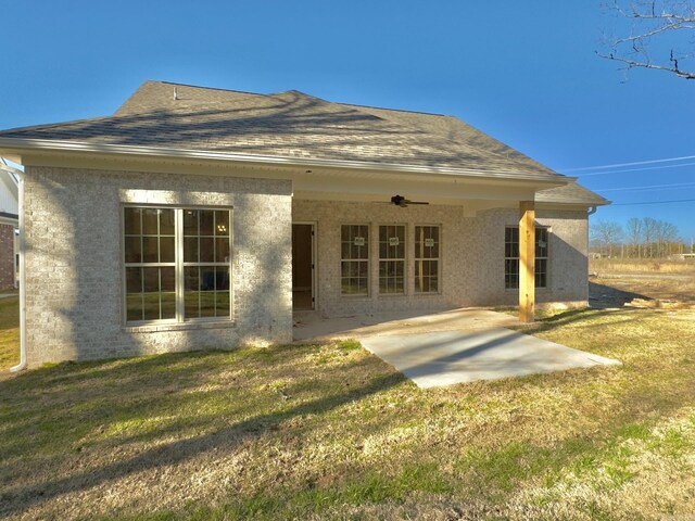 back of house with a yard, a patio, roof with shingles, and ceiling fan