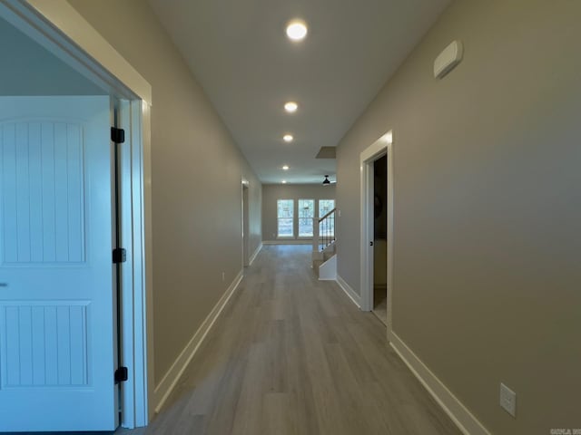 hall featuring recessed lighting, wood finished floors, and baseboards