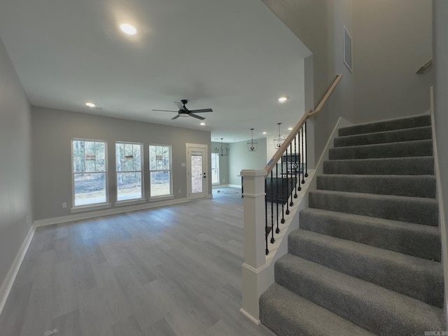 staircase featuring a wealth of natural light, visible vents, recessed lighting, and wood finished floors