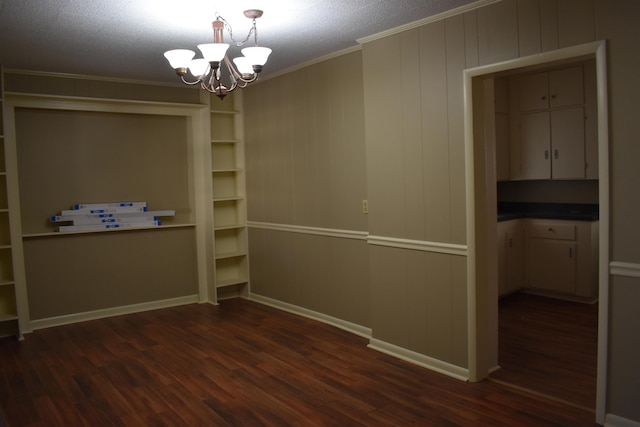 interior space with a chandelier, baseboards, dark wood-style floors, and crown molding