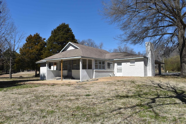 view of front of home featuring brick siding, a front yard, and a sunroom