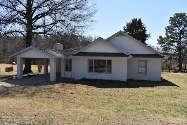 back of house featuring a carport, a lawn, and brick siding