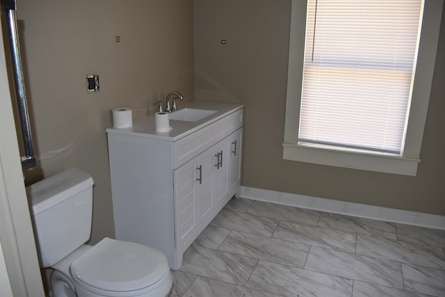 bathroom featuring baseboards, toilet, marble finish floor, and vanity