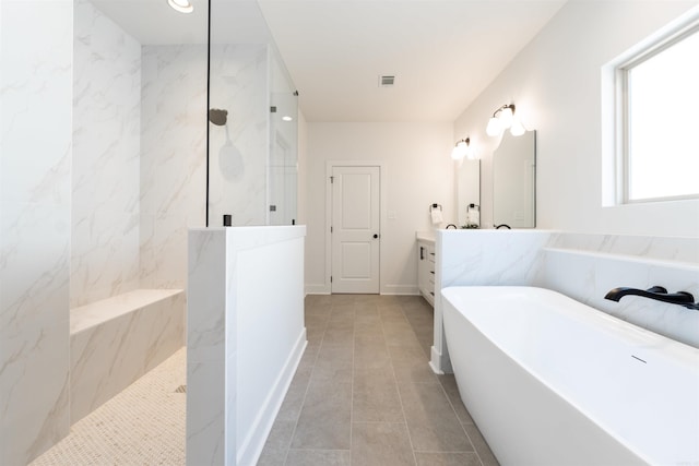 bathroom featuring vanity, visible vents, a marble finish shower, a freestanding tub, and tile patterned floors