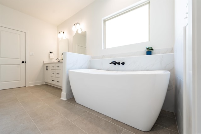 full bath featuring tile patterned floors, a soaking tub, and vanity