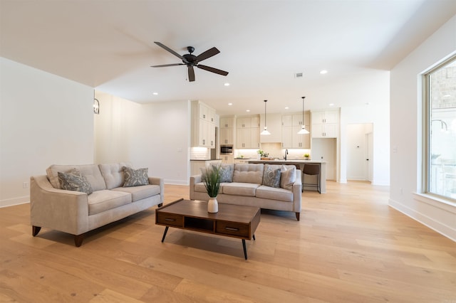 living area with recessed lighting, baseboards, and light wood finished floors