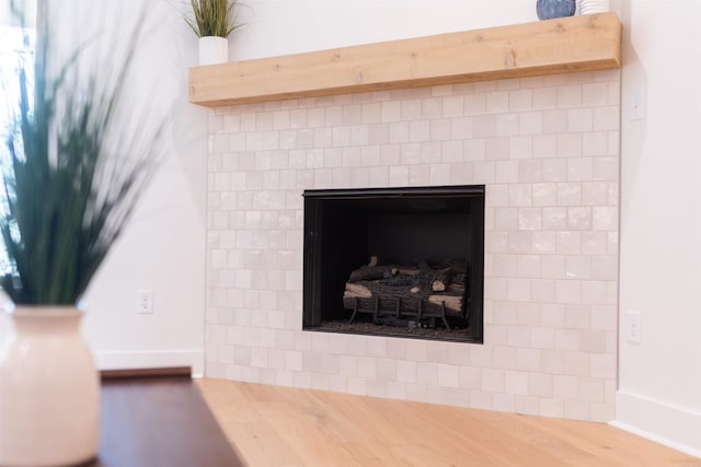 interior details featuring baseboards, wood finished floors, and a fireplace