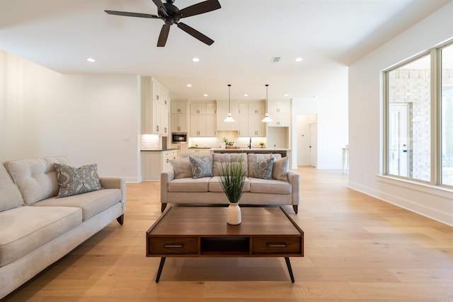 living room with recessed lighting, light wood-type flooring, and visible vents