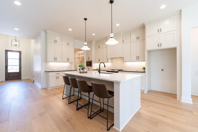 kitchen featuring a sink, white cabinets, and light wood finished floors