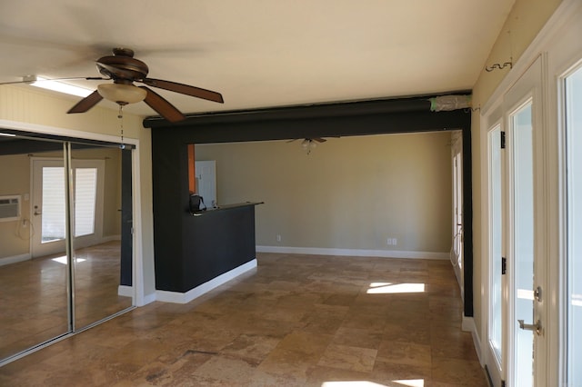 interior space featuring baseboards and a ceiling fan