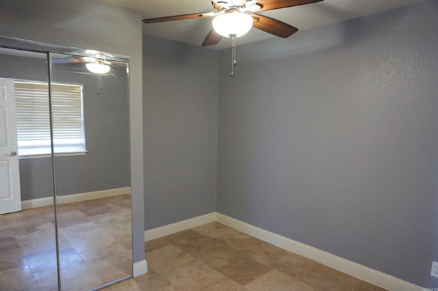 unfurnished room featuring ceiling fan and baseboards