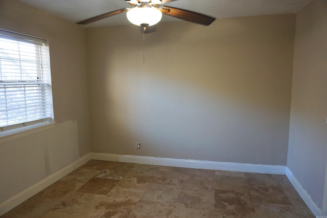 empty room featuring ceiling fan and baseboards