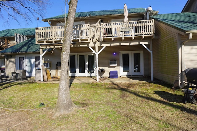 back of property featuring french doors, a lawn, and a wooden deck