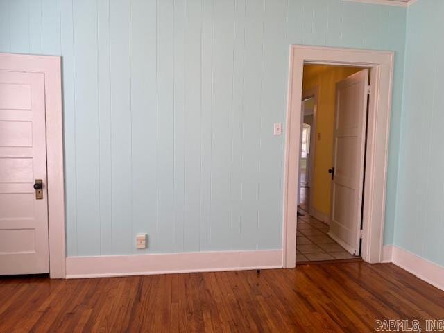 unfurnished room featuring dark wood-style floors and baseboards