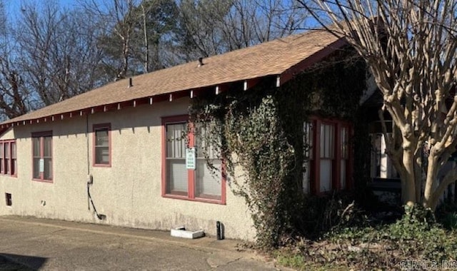 view of home's exterior with crawl space and stucco siding