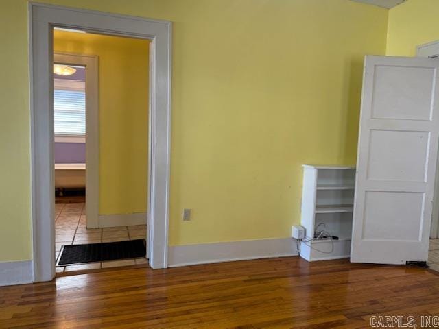 empty room with baseboards and wood finished floors