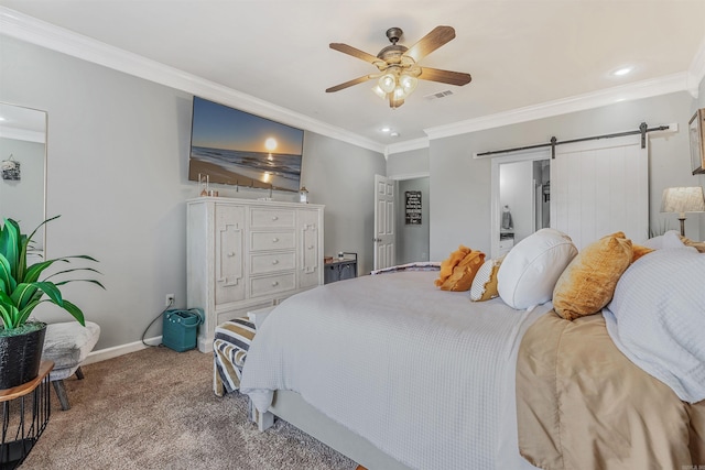 carpeted bedroom featuring visible vents, baseboards, crown molding, and a barn door