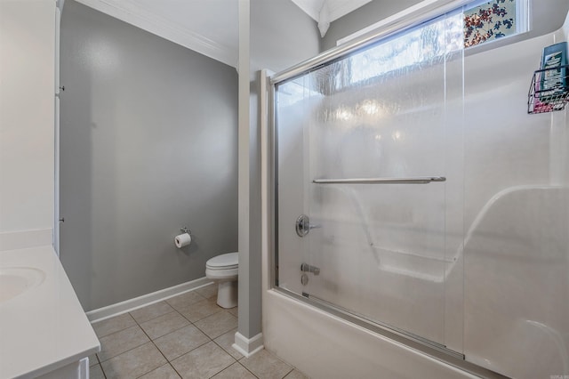 full bathroom with vanity, baseboards, bath / shower combo with glass door, tile patterned flooring, and toilet