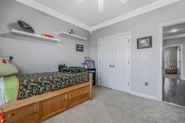 bedroom with a ceiling fan, baseboards, a closet, crown molding, and light colored carpet