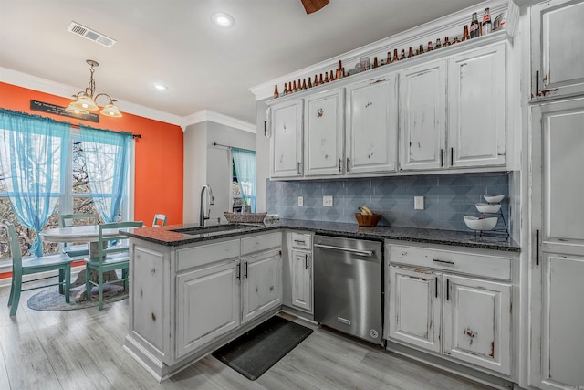 kitchen featuring visible vents, a peninsula, a sink, stainless steel dishwasher, and backsplash