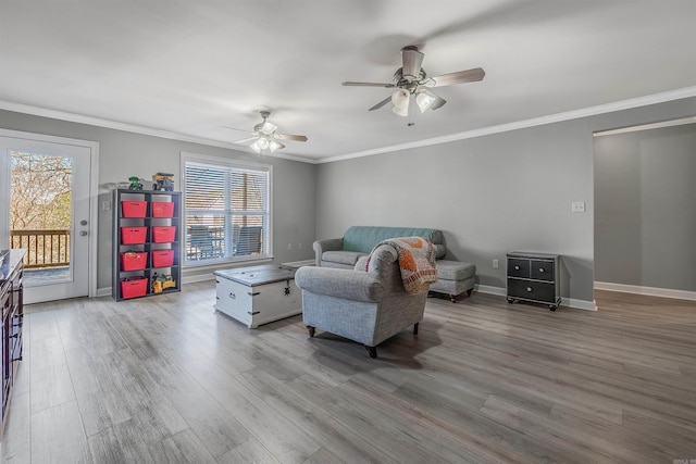 living room with baseboards, a ceiling fan, wood finished floors, and crown molding