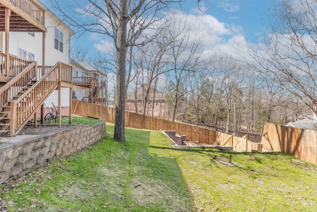 view of yard with a fenced backyard, stairway, and a deck