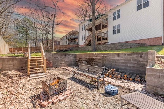 view of yard featuring stairway, an outdoor fire pit, and fence