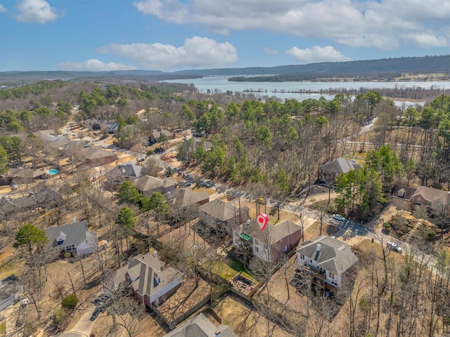 aerial view with a water view and a wooded view