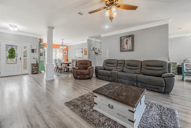 living area with visible vents, light wood finished floors, crown molding, and ornate columns