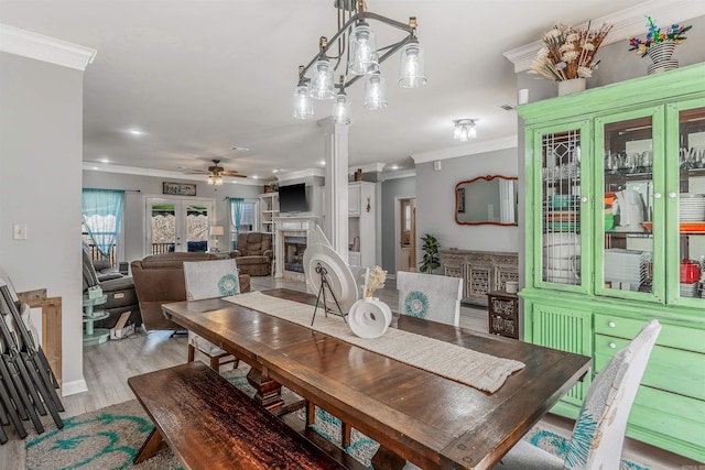 dining area with light wood-style flooring, recessed lighting, a fireplace, ceiling fan, and ornamental molding