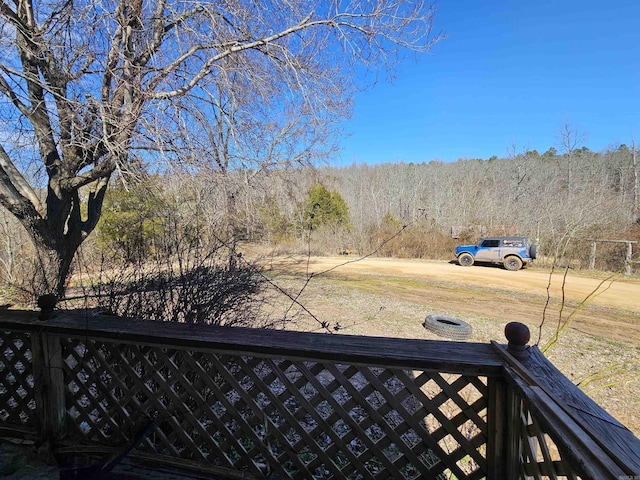 view of yard with a wooded view and fence