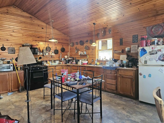 kitchen featuring a sink, lofted ceiling, black range with gas stovetop, and freestanding refrigerator