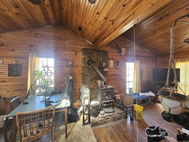 living area featuring wooden ceiling, lofted ceiling, wood finished floors, and a wood stove