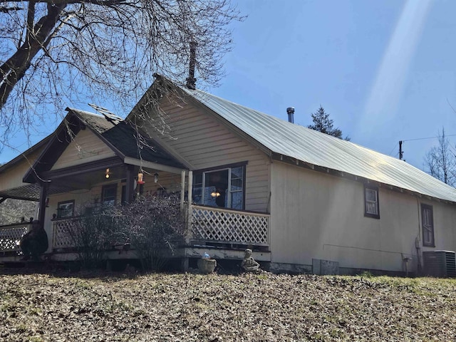 view of property exterior featuring metal roof, a porch, and cooling unit