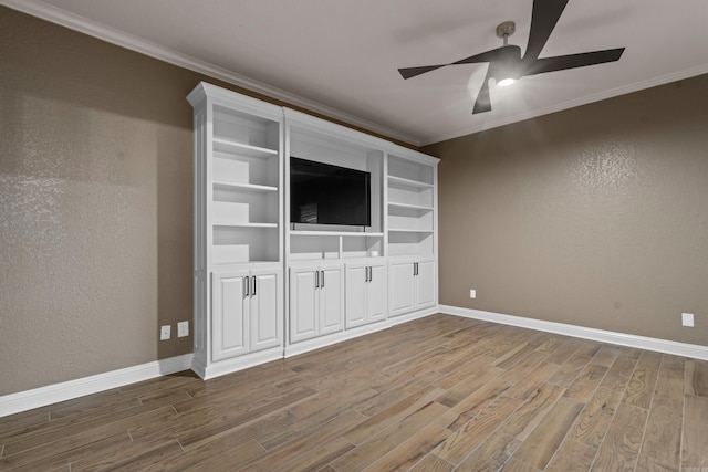 unfurnished living room featuring ceiling fan, wood finished floors, baseboards, and ornamental molding