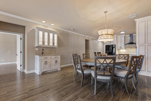 dining area with visible vents, baseboards, dark wood-style flooring, and crown molding