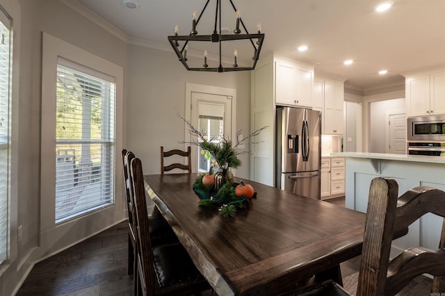 dining space with dark wood-type flooring, ornamental molding, recessed lighting, an inviting chandelier, and baseboards