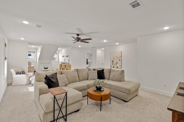 living area featuring recessed lighting, visible vents, baseboards, and light colored carpet