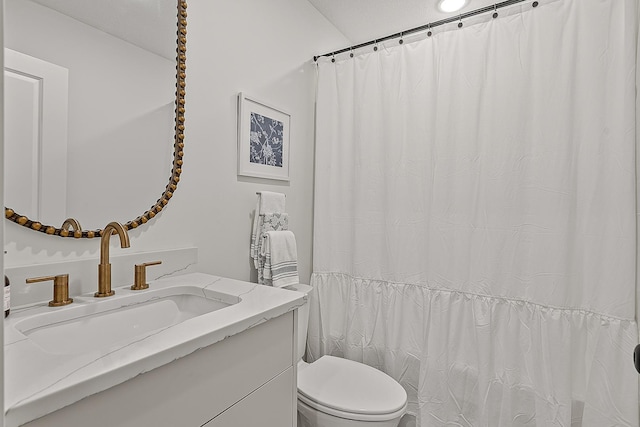 bathroom with curtained shower, toilet, and vanity