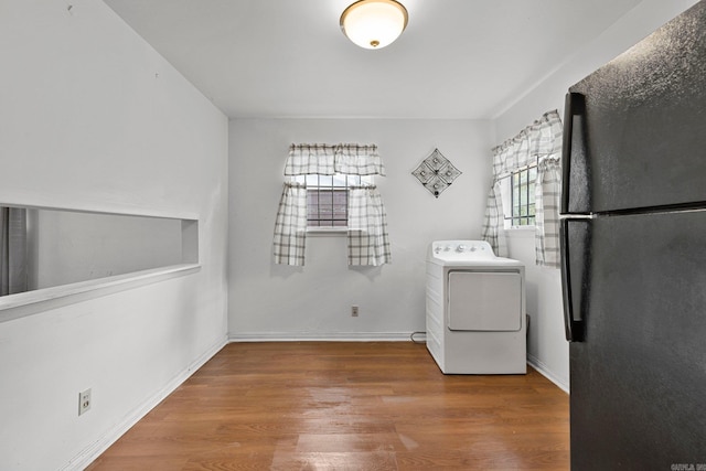 laundry room with laundry area, washer / clothes dryer, baseboards, and wood finished floors