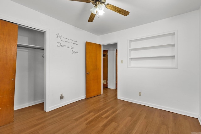 unfurnished bedroom with wood finished floors, baseboards, a closet, and ceiling fan