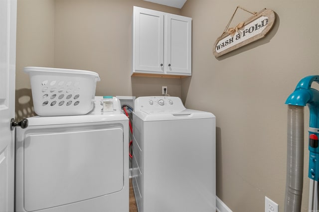 clothes washing area featuring cabinet space and separate washer and dryer