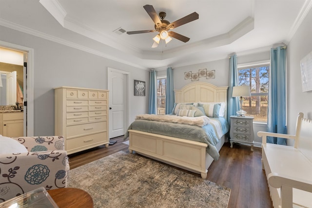 bedroom with dark wood-style floors, visible vents, crown molding, and a raised ceiling