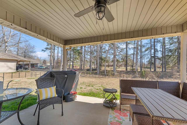 view of patio featuring outdoor dining area, a ceiling fan, and fence