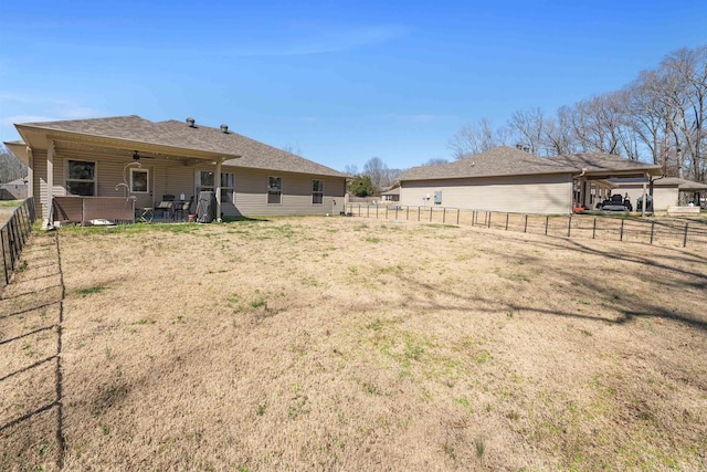 rear view of property with a fenced backyard, a ceiling fan, and a patio area